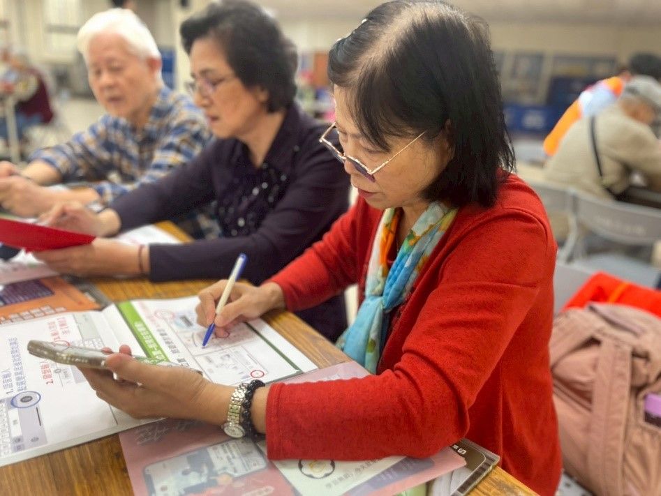 長輩認真記錄學生所教學的LINE操作步驟